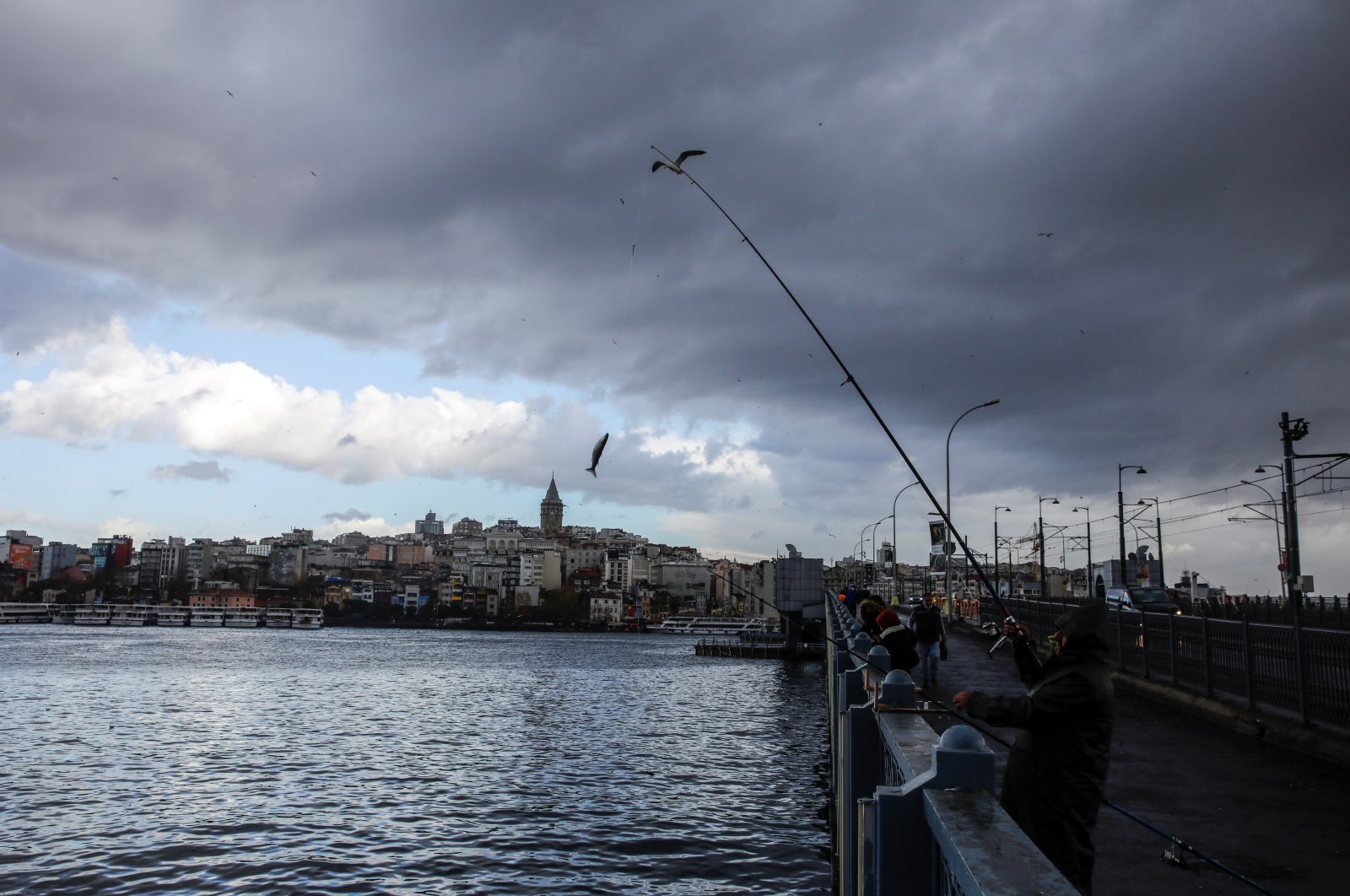 A man fishes from the Galata Bridge in Istanbul, Turkey, Nov. 30, 2021. (Reuters Photo)