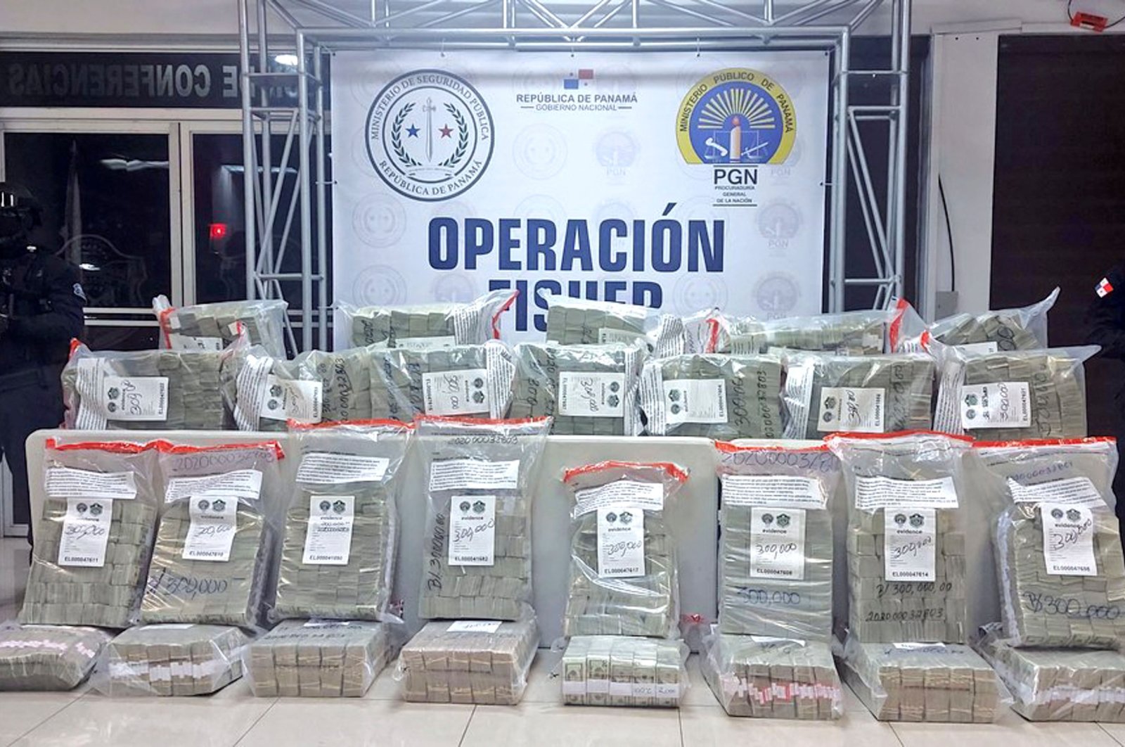 Police personnel guard packages of seized $10 million in U.S. dollar bills seized from an alleged criminal group linked to Colombia&#039;s Clan del Golfo cartel, Colon, Panama, Dec. 2, 2021. (AFP Photo / Panama&#039;s National Police Press Office)