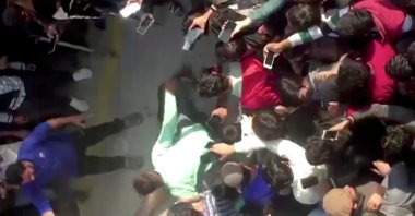 People gather around the body of a Sri Lankan manager in this screen grab taken from a video after an attack on a factory manager in Sialkot, Pakistan, Dec. 3, 2021. (REUTERS TV via REUTERS)