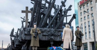 Leader of French far-right party Rassemblement National (RN) and candidate for the French presidential elections Marine Le Pen (C) takes part in a wreath-laying ceremony in front of the Monument to the Fallen and Murdered in the East commemorating victims of Soviet invasion on 1939 in Warsaw, Poland, Dec. 3, 2021. (AFP Photo)