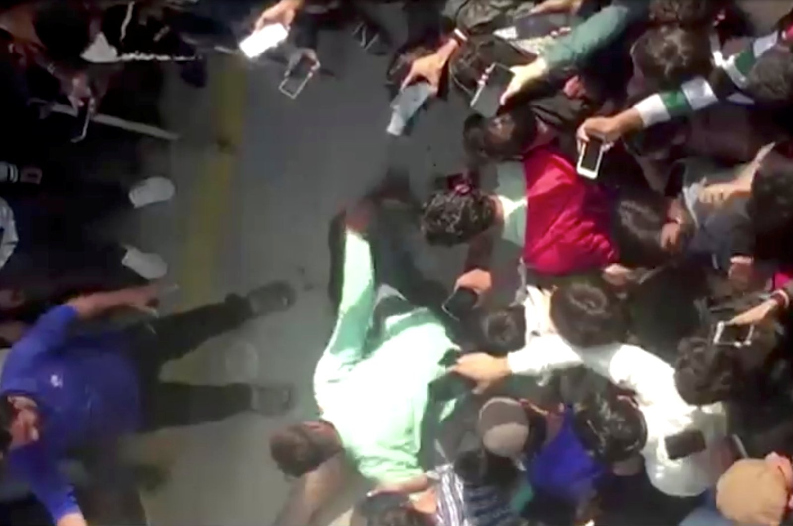 People gather around the body of a Sri Lankan manager in this screen grab taken from a video after an attack on a factory manager in Sialkot, Pakistan, Dec. 3, 2021. (REUTERS TV via REUTERS)