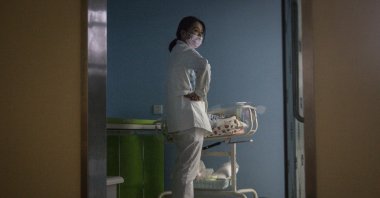 A maternity nurse wears a mask as she cares for a newborn at a private maternity hospital in Wuhan, Hubei, China, March 12, 2020. (Getty Images)
