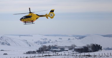 A Western Power Distribution maintenance helicopter flies over the snow-covered fields in Buxton after Storm Arwen, Buxton, Derbyshire, Britain, Nov. 29, 2021. (Reuters Photo)