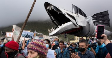 A giant puppet of a snoek, a type of common local mackerel, is displayed as hundreds of people take part in a protest against the plan by Dutch oil company Shell to conduct underwater seismic surveys along South Africa's east coast, at Muizenberg Beach, in Cape Town, Dec. 5, 2021.