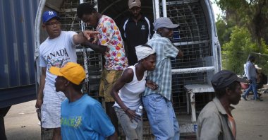 Undocumented Haitians, detained by immigration officials, step out of a bus to be deported to Haiti, in Dajabon, Dominican Republic, Friday, Nov. 19, 2021.  (AP Photo/Matias Delacroix)
