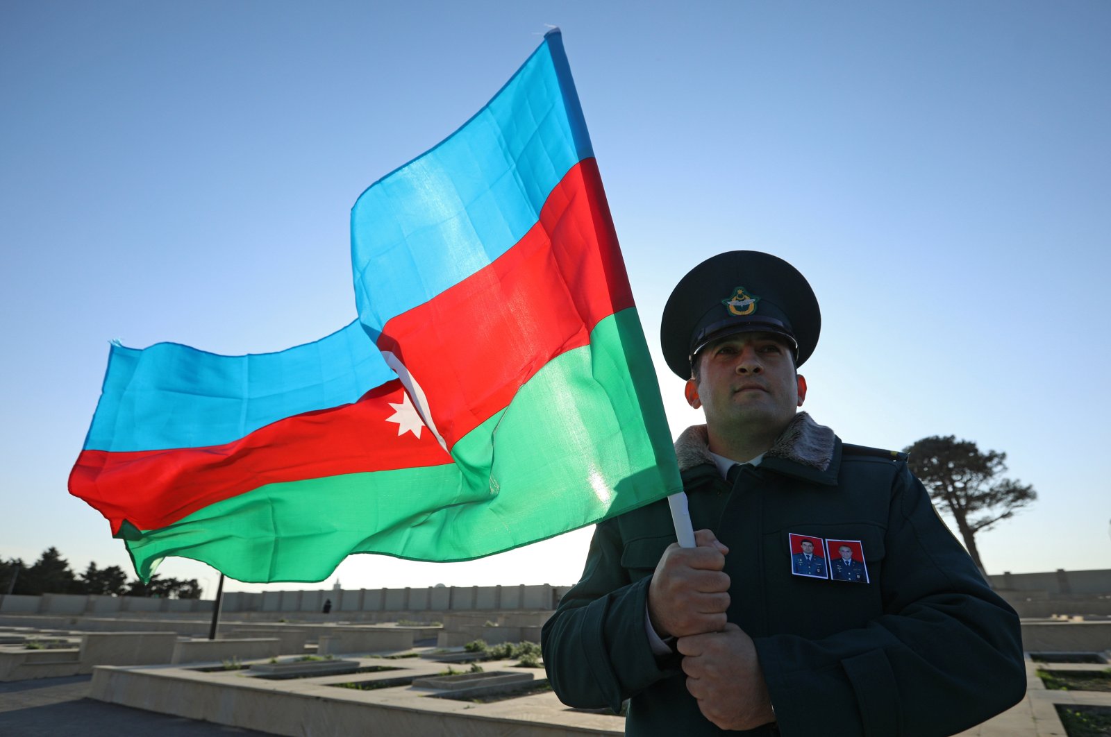 A service member holds the Azerbaijani national flag during a funeral service for servicemen killed in the crash of an Azerbaijani military helicopter, in Baku, Azerbaijan, Dec. 1, 2021. (Reuters Photo)