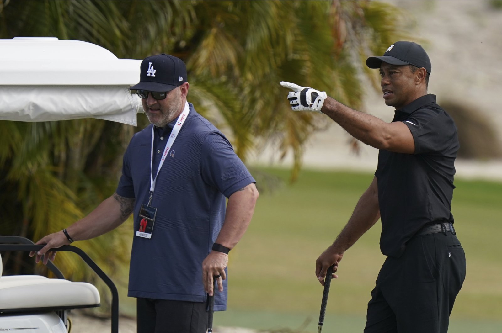 Tiger Woods (R) speaks with his trainer Kolby Wayne during a practice session at the Albany Golf Club in the Bahamas, Dec. 4, 2021. (AP Photo)
