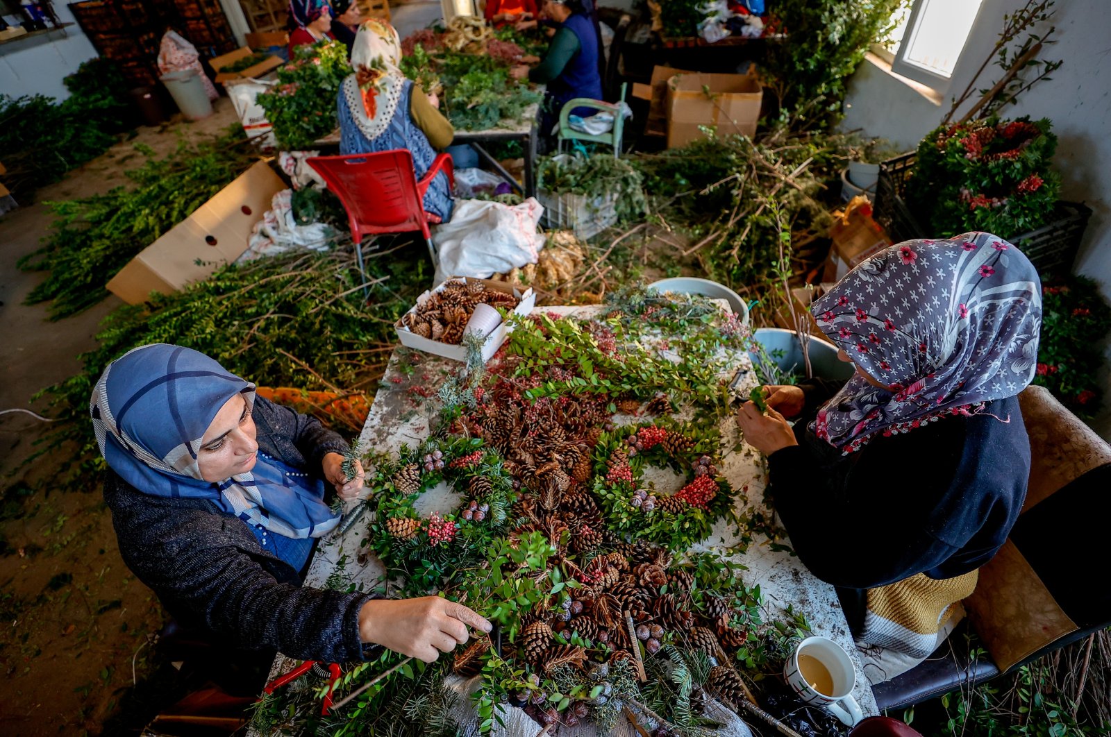 Women work on wreaths for the upcoming Christmas and New Year’s Eve holidays, in the southern province of Antalya, Turkey, Dec. 5, 2021. (AA Photo)