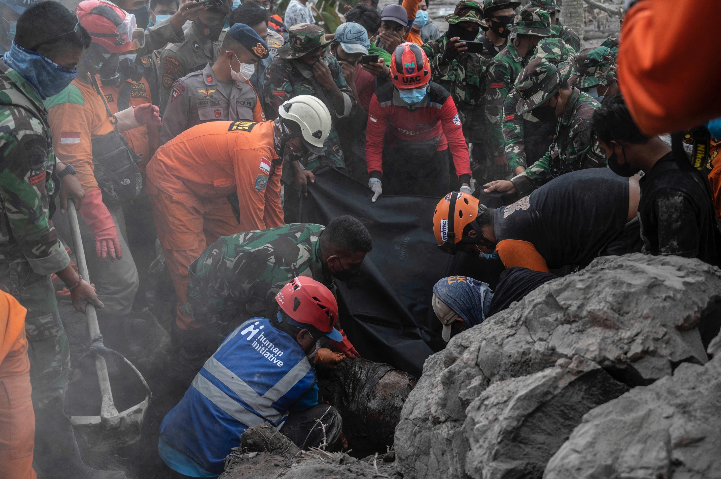Tim penyelamat mengevakuasi jenazah korban di Desa Sumber Wuluh pasca erupsi Gunung Semeru, Lumajang, Indonesia, 6 Desember 2021. (AFP Photo)