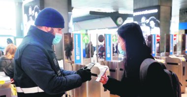 Staff of the Trenord transport company checks the QR code confirming that people received the COVID-19 vaccine at Cadorna Rail station in Milan, Italy, Dec. 6, 2021. (EPA Photo)