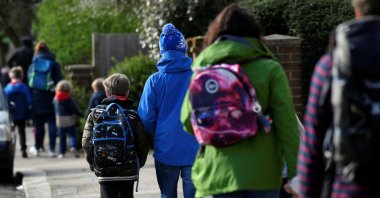 Parents walk their children to school on the last day before their official closure, as the spread of the coronavirus disease (COVID-19) continues, in West London, Britain, March 20, 2020. (Reuters File Photo)