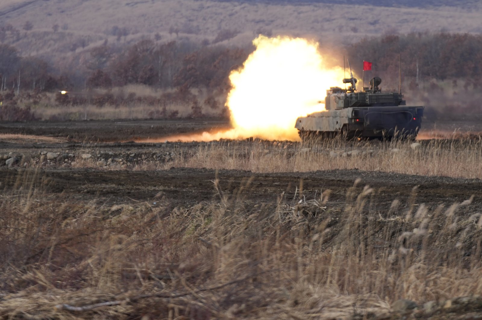 A Japanese Ground-Self Defense Force (JGDDF) Type 90 tank fires its gun at a target during the annual drill with live ammunitions exercise at Minami Eniwa Camp, in Eniwa, northern Japan island of Hokkaido, Dec. 6, 2021. (AP Photo) 