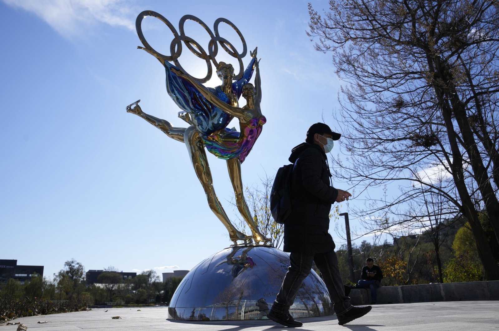 A visitor to Shougang Park walks past a sculpture for the Beijing Winter Olympics in Beijing, China, Nov. 9, 2021. (AP Photo)