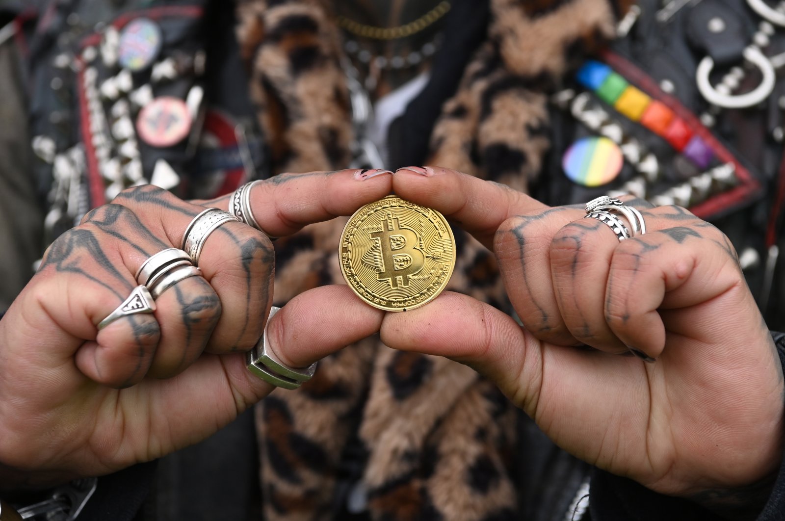 A performer holds a metal representation of a Bitcoin during a photocall in front of the Tower of London in London, Britain, Nov. 24, 2021. (EPA/FACUNDO ARRIZABALAGA)