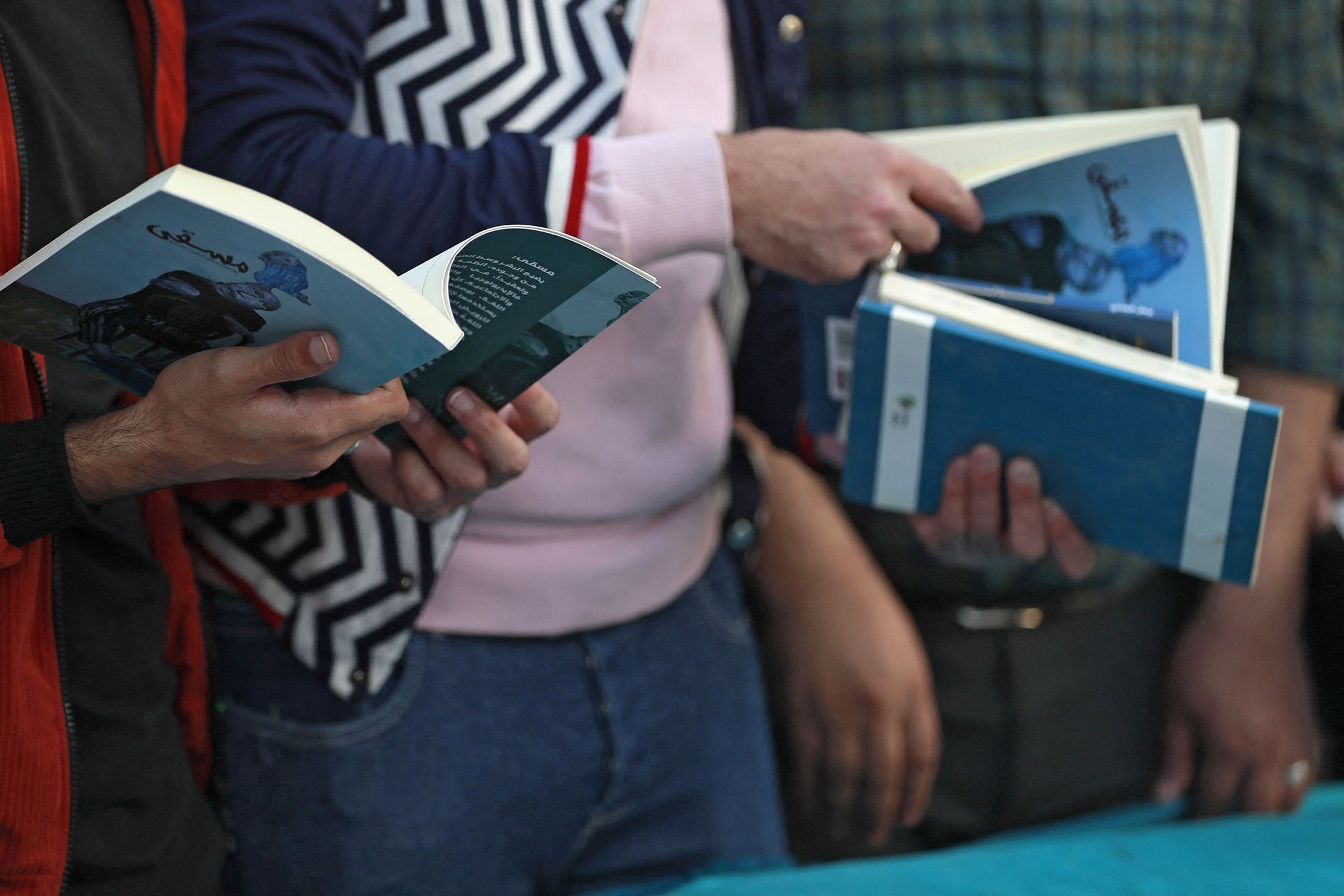 Iraqis browse through books during the eighth edition of an annual book festival in the Abu Nawas street, known for its bookshops and book stalls, along the banks of the Tigris, in the capital Baghdad, Iraq, Nov. 27, 2021. (AFP Photo)
