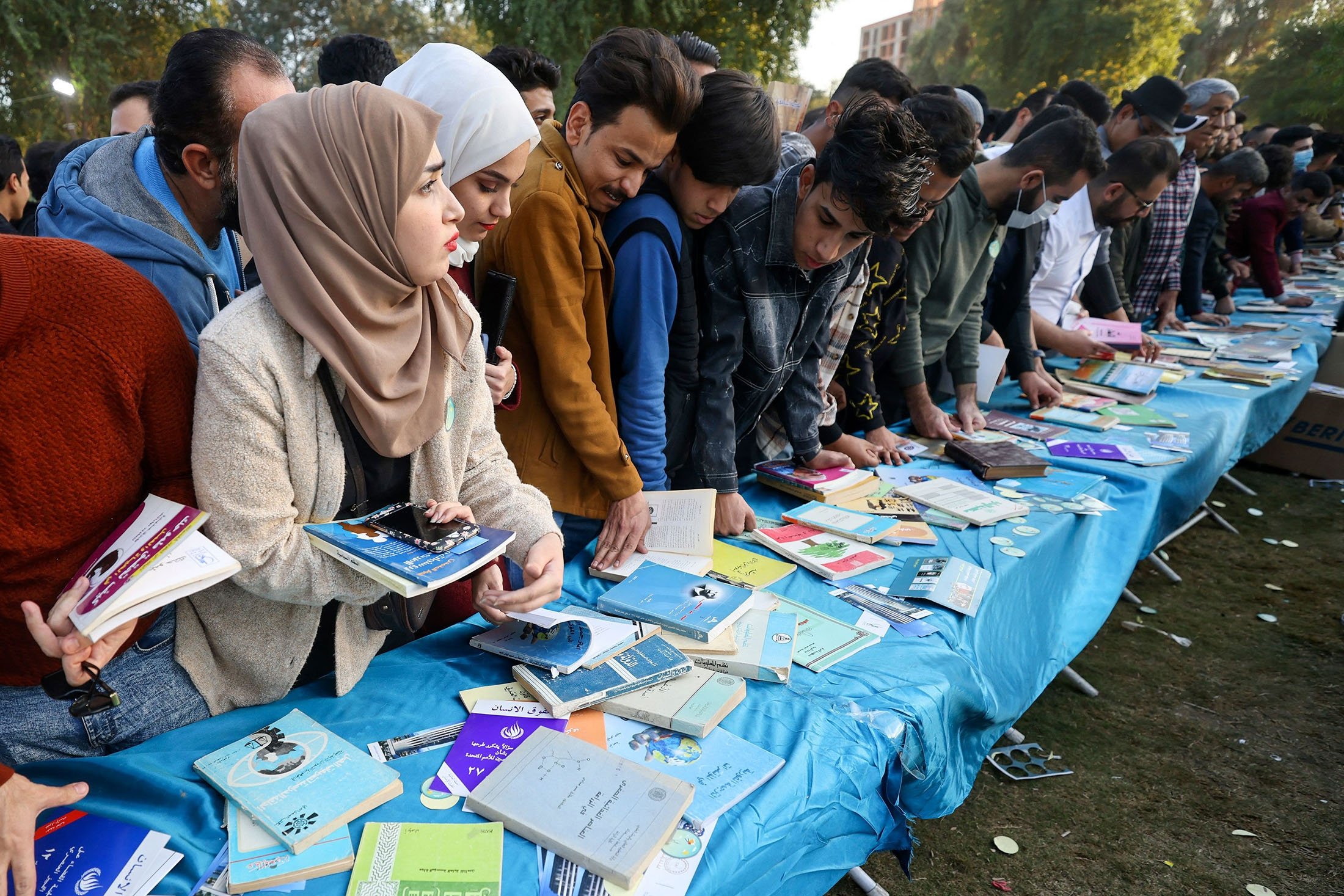 Iraqis browse through books during the eighth edition of an annual book festival in the Abu Nawas street, known for its bookshops and book stalls, along the banks of the Tigris, in the capital Baghdad, Iraq, Nov. 27, 2021. (AFP Photo)