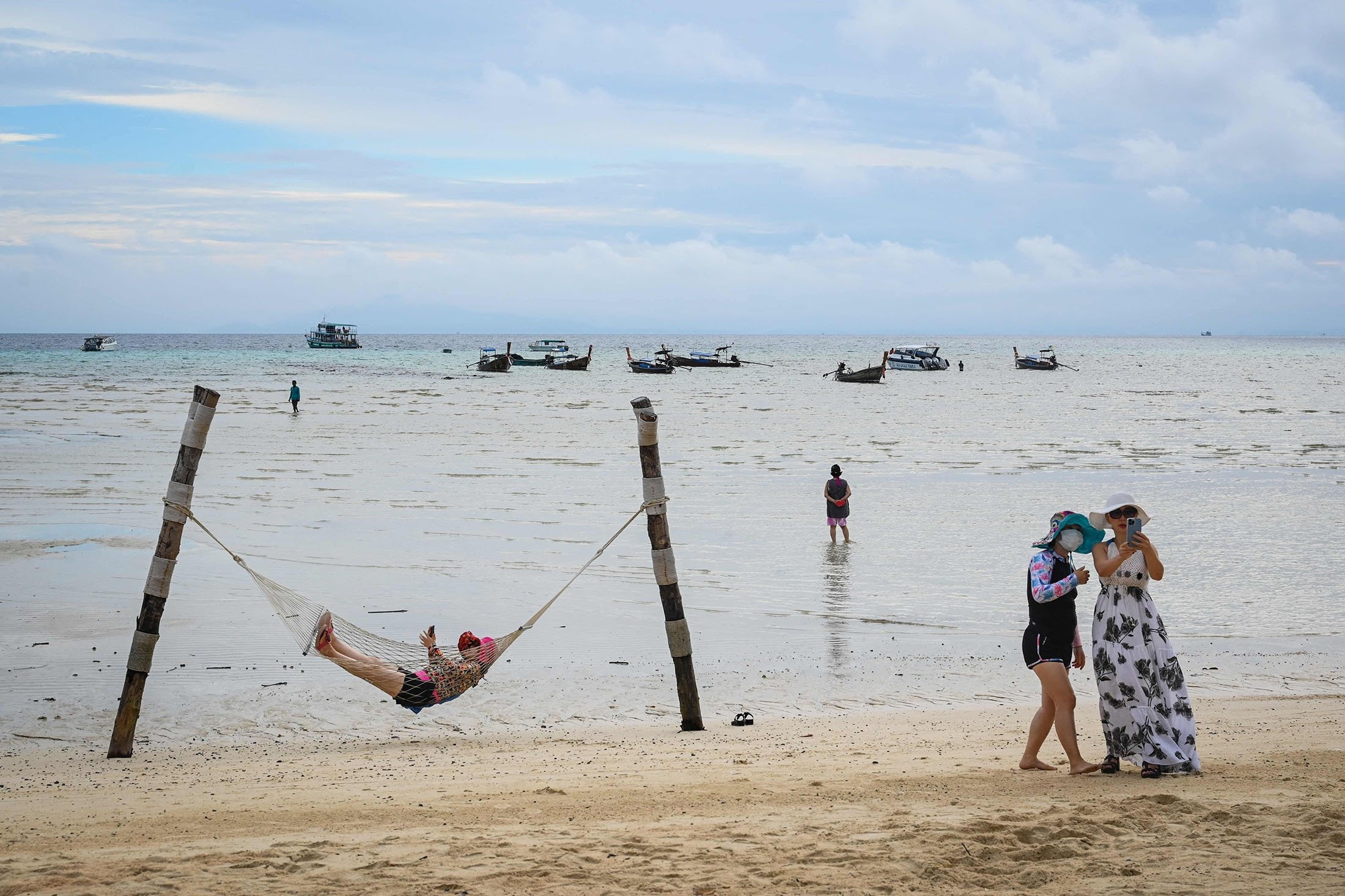 Tourists pose for photos with their mobile phones on a beach on the Phi Phi Don island, Thailand, Nov. 26, 2021. (AFP Photo)