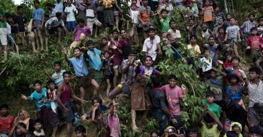 Rohingya Muslim refugees from Myanmar&#039;s Rakhine state stand on a slope and stretch their arms out to receive food being distributed near the Balukhali refugee camp in Cox&#039;s Bazar, Bangladesh, Sept. 20, 2017. (AP File Photo)