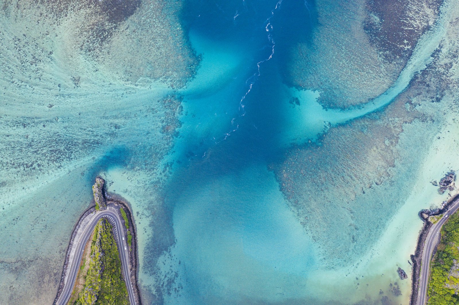 An aerial view of turquoise waters of a lagoon surrounding the Maconde Viewpoint along the coastal road, aerial view at Bel Ombre, Baie Du Cap, Indian Ocean. (Getty Images)