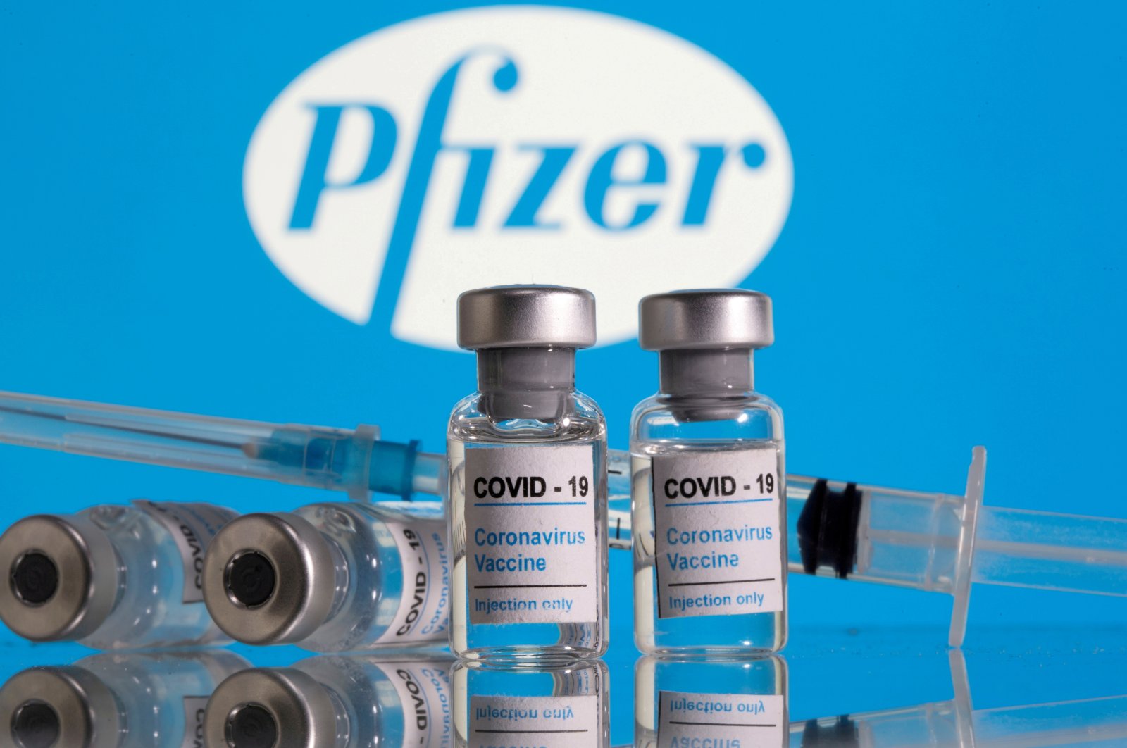 A file photo shows vials labeled "COVID-19 Coronavirus Vaccine" and a syringe in front of the Pfizer logo in this illustration taken Feb. 9, 2021. (Reuters Photo)