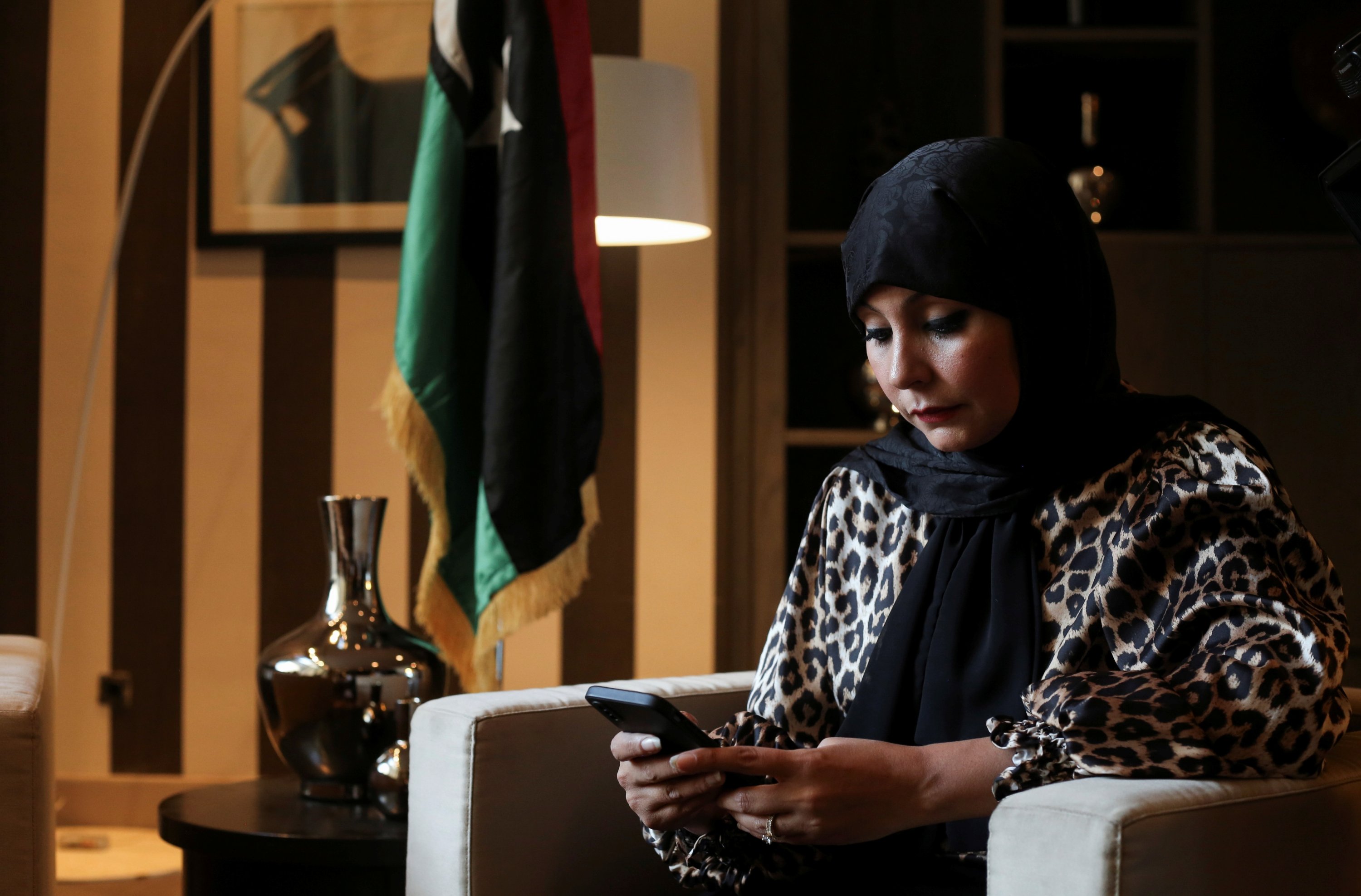 Hunaida Tumia, satu dari hanya dua wanita yang mencalonkan diri dalam pemilihan presiden pertama Libya, memeriksa teleponnya selama wawancara dengan Reuters di Tripoli, Libya, pada 1 Desember 2021. (Foto Reuters)