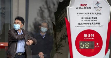 People stand near a clock counting down the days to the opening ceremony of the 2022 Winter Olympics in Beijing, China, Dec. 8, 2021. (AP Photo)