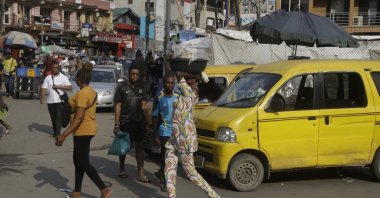 People walk past a busy market in Lagos, Nigeria, Dec. 1, 2021. (AP Photo)