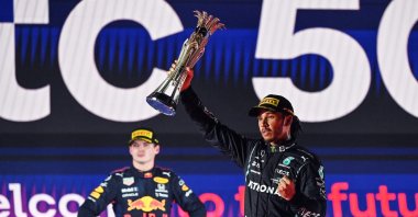 Lewis Hamilton (R) reacts with his trophy flanked by second-placed Red Max Verstappen (L), in Jeddah, Saudi Arabia, Dec. 5, 2021. (AFP PHOTO) 