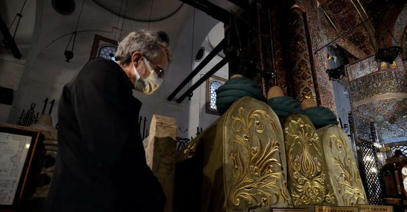 A visitor contemplates at the tombs inside Mevlana Museum in Konya, central Turkey, Dec. 8, 2021. (AA PHOTO)