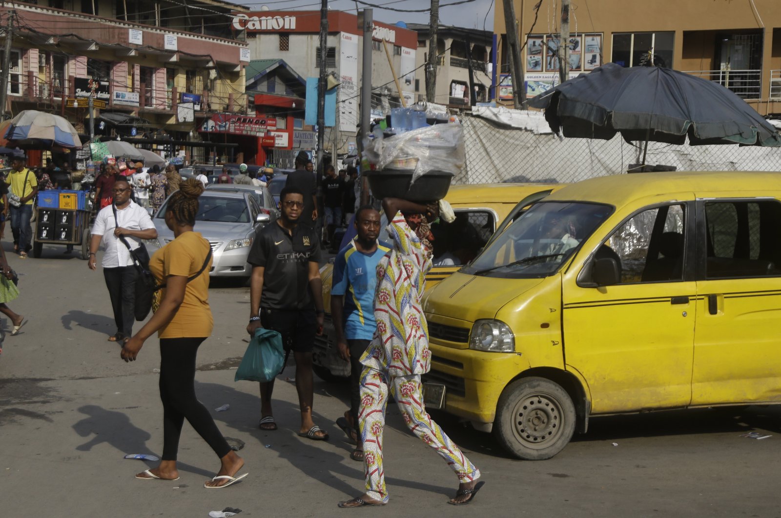 People walk past a busy market in Lagos, Nigeria, Dec. 1, 2021. (AP Photo)