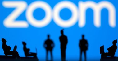 Small toy figures are seen in front of the Zoom logo in this illustration picture taken March 15, 2021. (Reuters Photo)