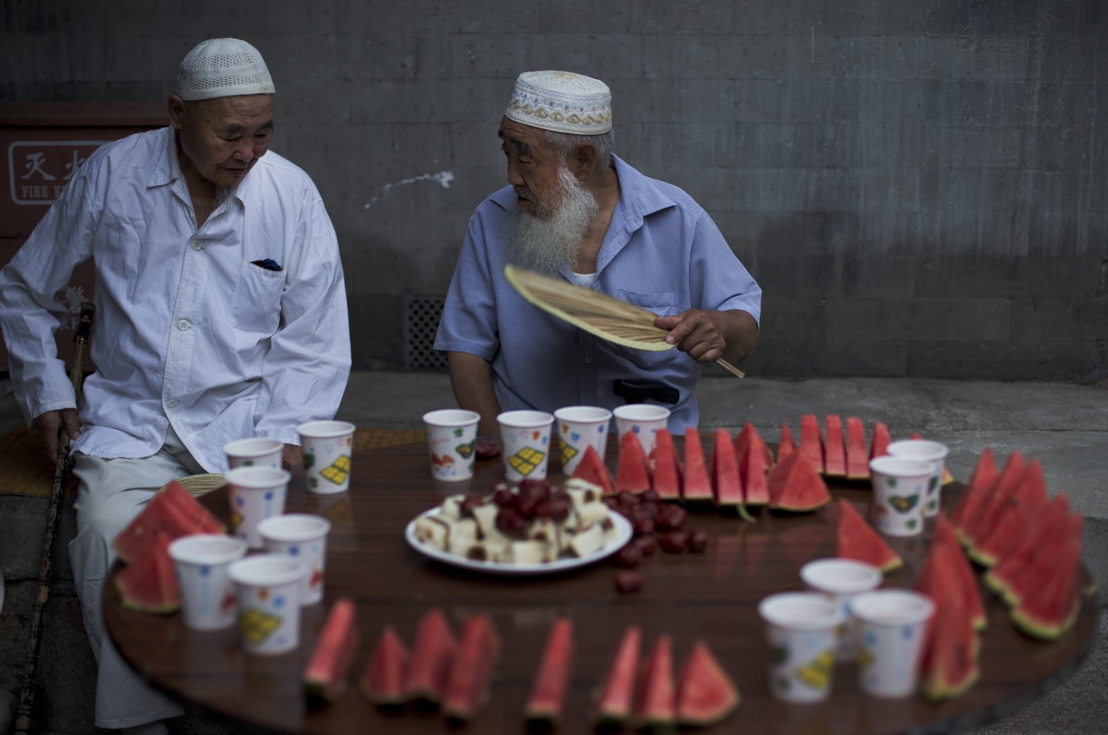 Chinese Muslim men chat as they wait for the time to break their fast during the Muslim holy month of Ramadan at the Niujie mosque, the oldest and largest mosque in Beijing, China, July 2, 2014. (AP Photo)