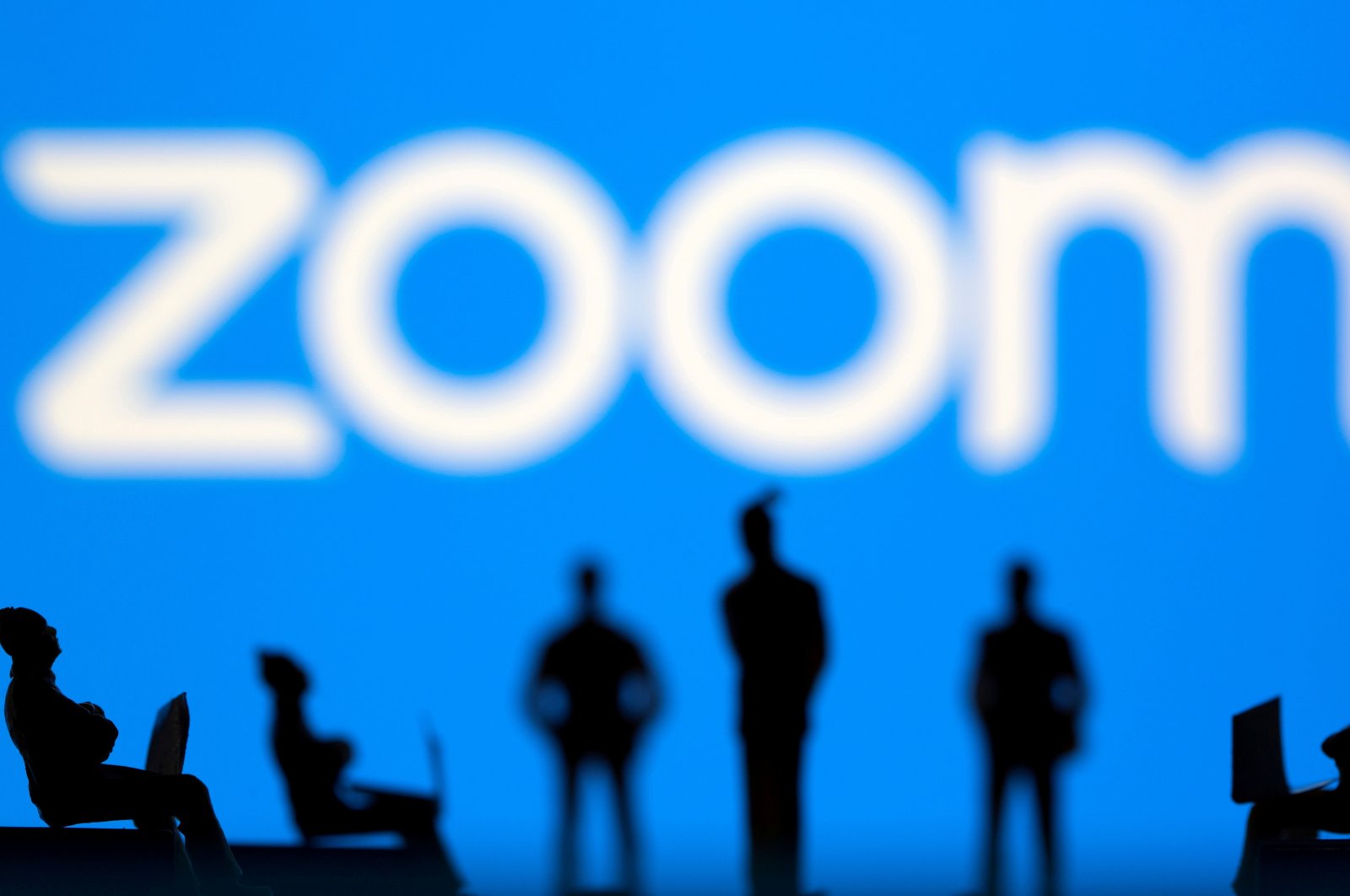 Small toy figures are seen in front of the Zoom logo in this illustration picture taken March 15, 2021. (Reuters Photo)