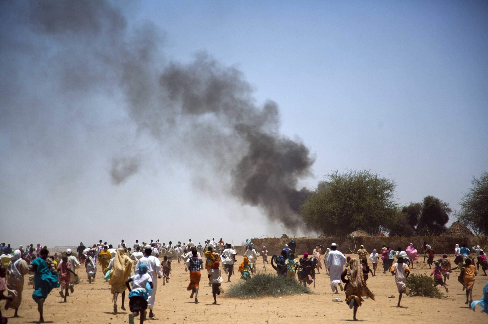 Villagers run away with their belongings from a fire in Kuma Garadayat, a village located in North Darfur, Sudan, May 19, 2011. (Reuters File Photo)