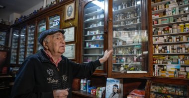 Melih Ziya Sezer shows the shelves filled with modern and ancient medicines at the pharmacy, in Istanbul, Turkey, Dec. 10, 2021. (DHA PHOTO)