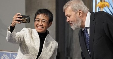 Nobel Peace Prize laureates Maria Ressa of the Philippines and Dmitry Muratov of Russia make a selfie during the gala award ceremony for the Nobel Peace prize, in Oslo, Norway, on Dec. 10, 2021.  (AFP Photo)