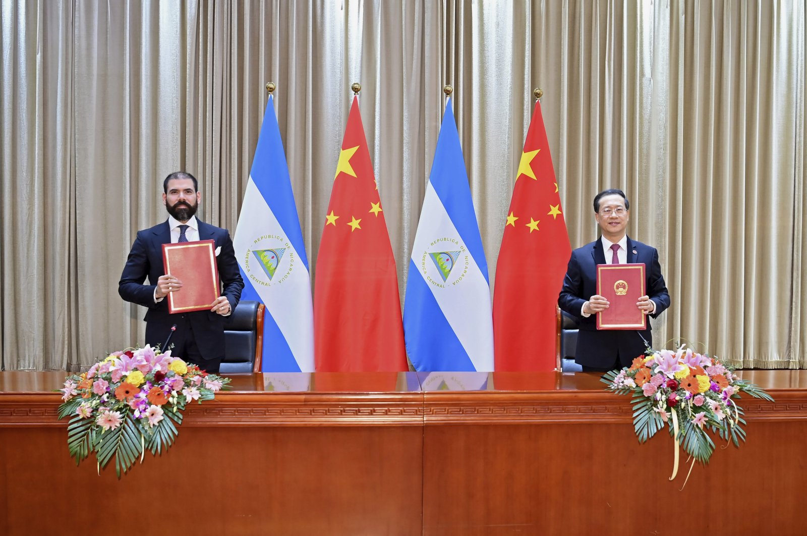 In this photo released by China’s Xinhua News Agency, representatives Laureano Ortega Murillo (L), son of and advisor to Nicaraguan President Daniel Ortega, and Chinese Vice Foreign Minister Ma Zhaoxu display their jointly signed communique on the resumption of diplomatic relations between the two countries in northern China’s Tianjin Municipality, Dec. 10, 2021. (AP Photo)