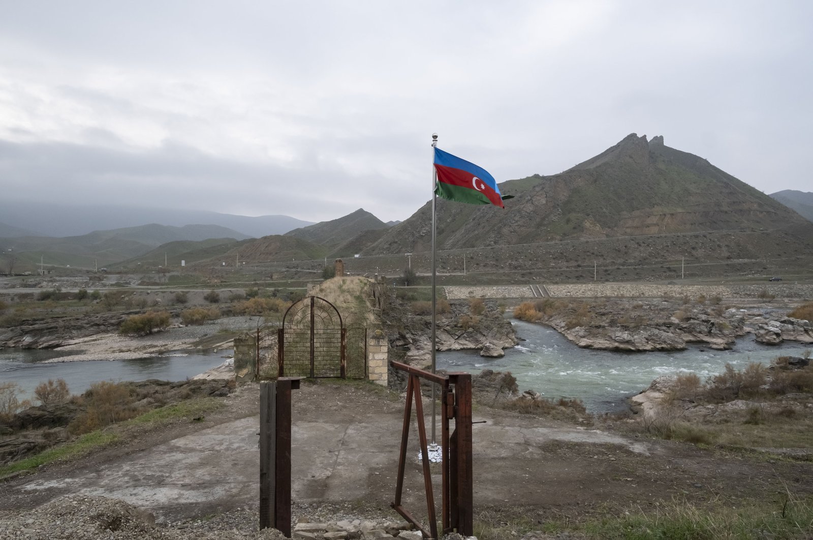 An Azerbaijani national flag flies next to the 13th century Khodaafarin Arch Bridge connecting the northern and southern banks of the Aras River located at the border of Azerbaijan and Iran, Dec. 15, 2020. (Getty Images)