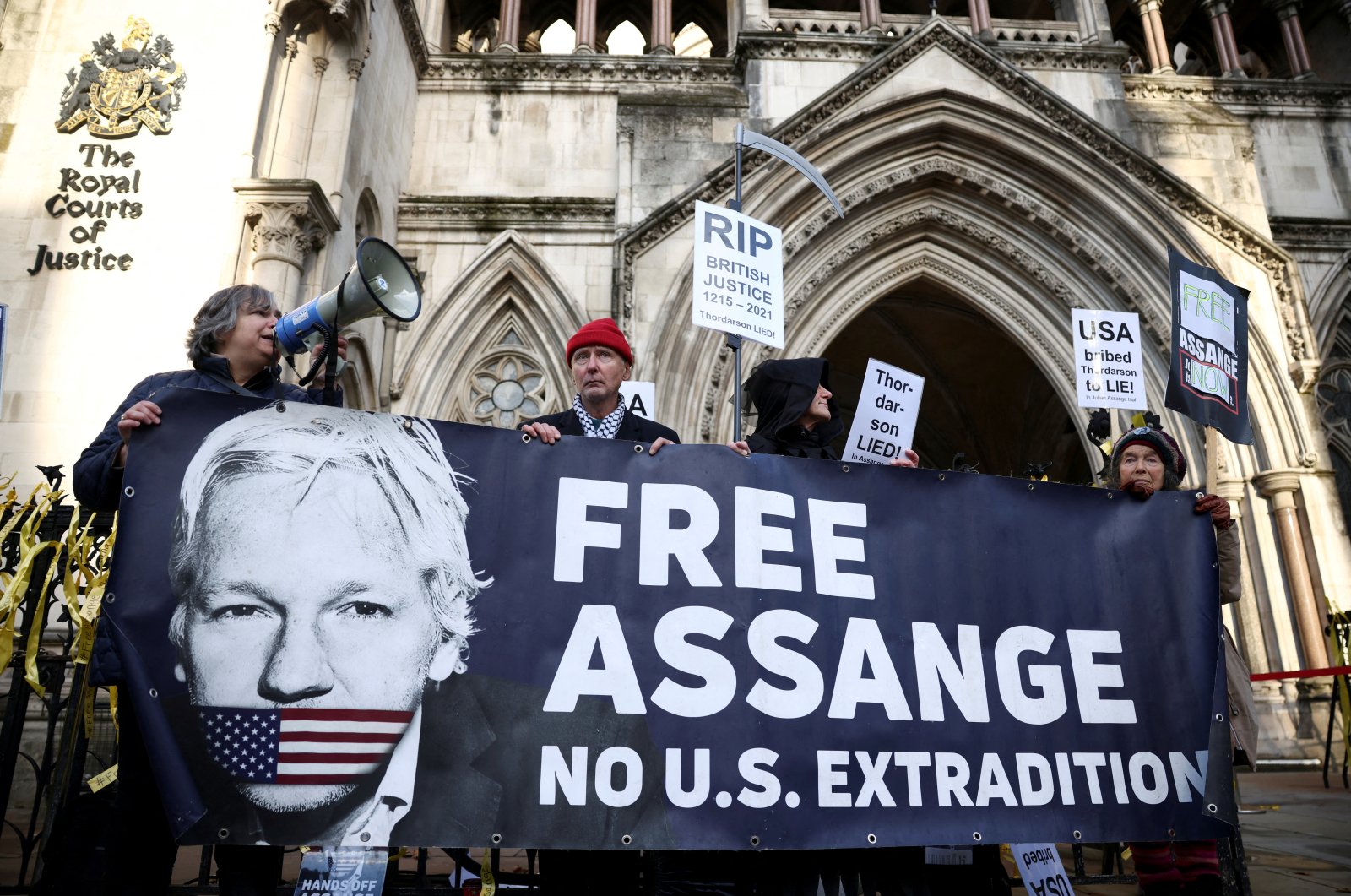 Supporters of Julian Assange display signs and a banner, outside the Royal Courts of Justice in London, Britain, Dec. 10, 2021. (Reuters Photo)