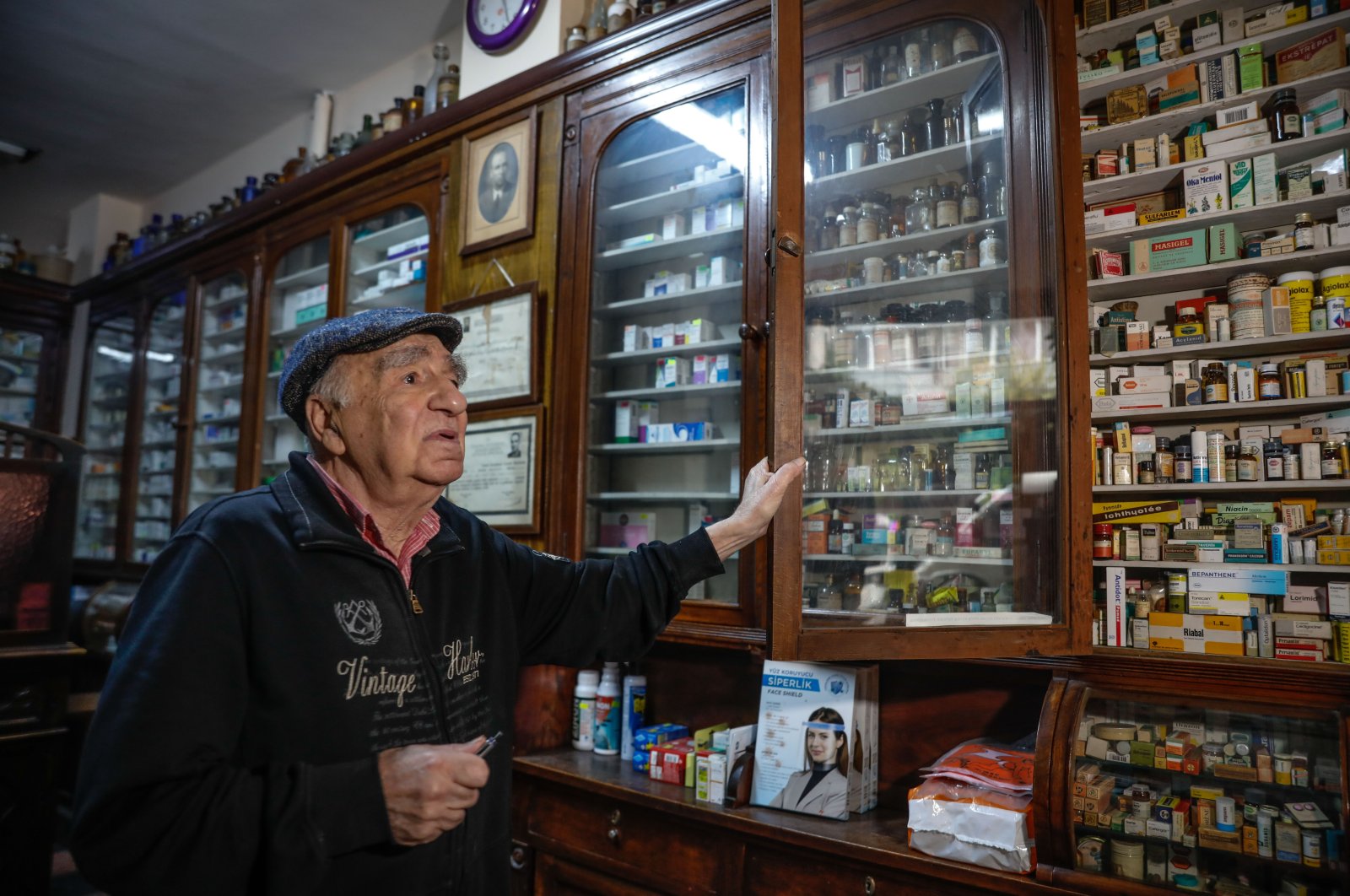 Melih Ziya Sezer shows the shelves filled with modern and ancient medicines at the pharmacy, in Istanbul, Turkey, Dec. 10, 2021. (DHA PHOTO)