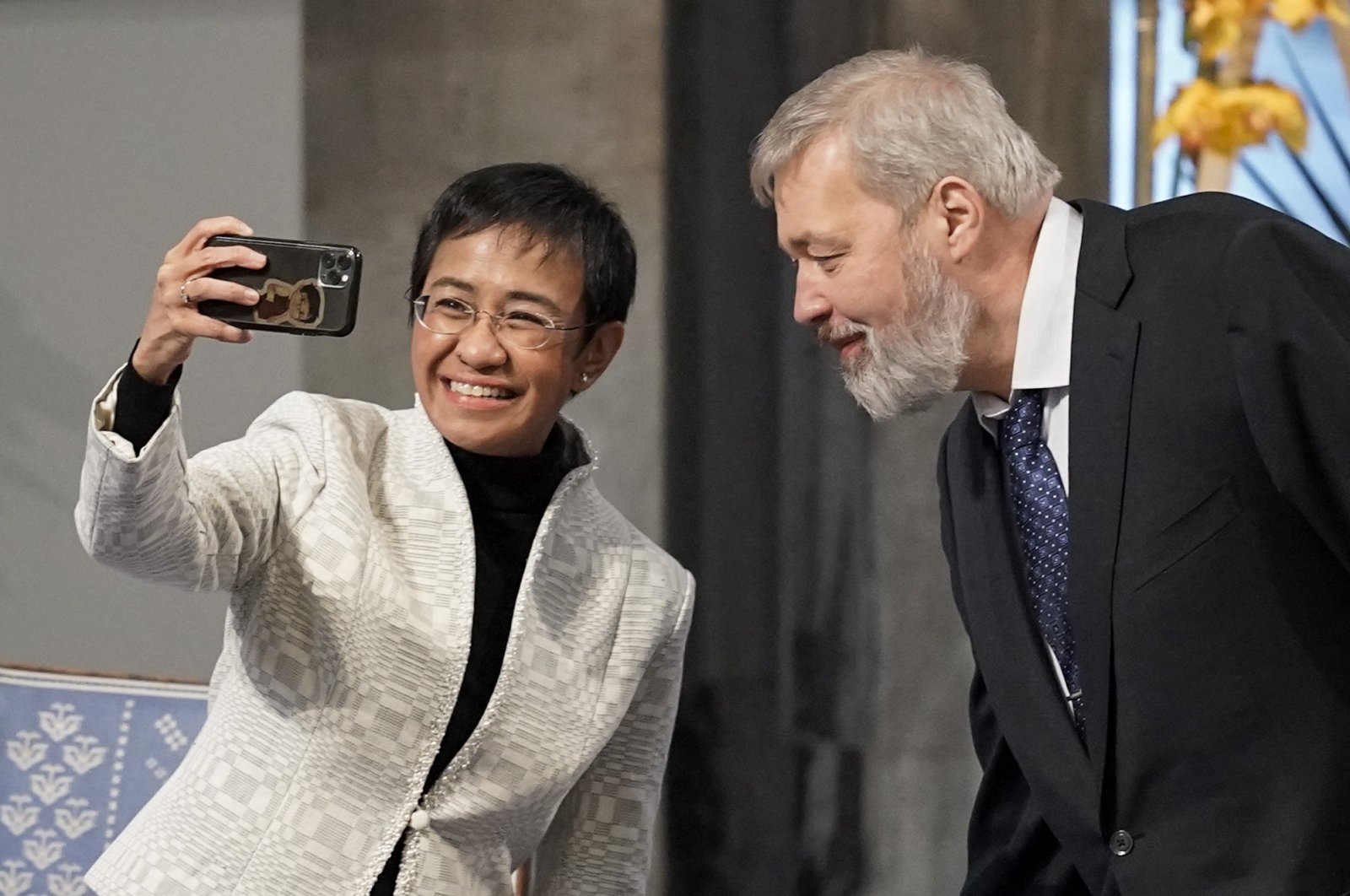 Nobel Peace Prize laureates Maria Ressa of the Philippines and Dmitry Muratov of Russia make a selfie during the gala award ceremony for the Nobel Peace prize, in Oslo, Norway, on Dec. 10, 2021.  (AFP Photo)