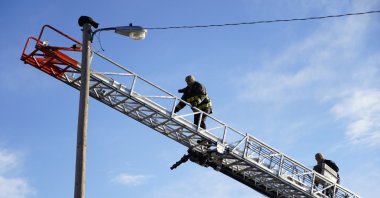 Aurora firefighters rescue Panther, a local cat who's been stuck on top of a 36-foot-high light pole for days, Aurora, Colorado, U.S., Dec. 10, 2021. (AP Photo)