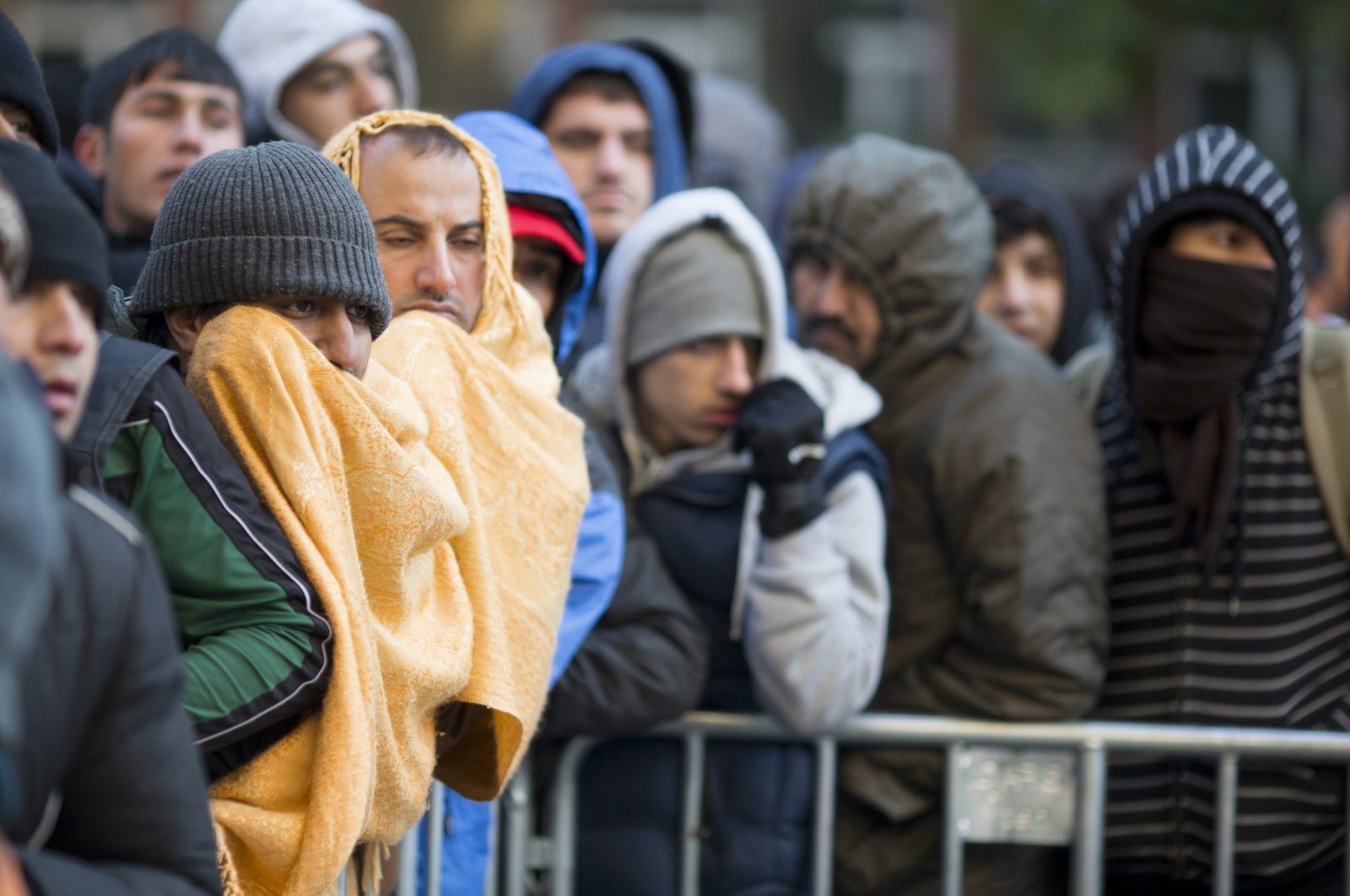 Refugees and migrants try to keep warm as temperatures hover around freezing as they wait for registration and allocation of a sleeping place on the premises of the State Office of Health and Welfare (LaGeSo) in Berlin, Germany, Oct. 12, 2015. (EPA Photo)