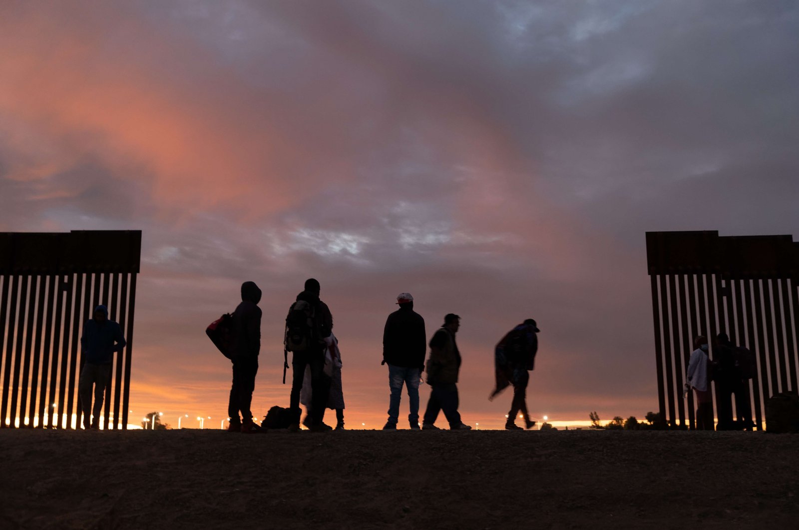 Parents-to-be from Haiti stand at a gap in the U.S.-Mexico border wall after having traveled from South America to the United States, Dec. 10, 2021 in Yuma, Arizona. (AFP Photo)