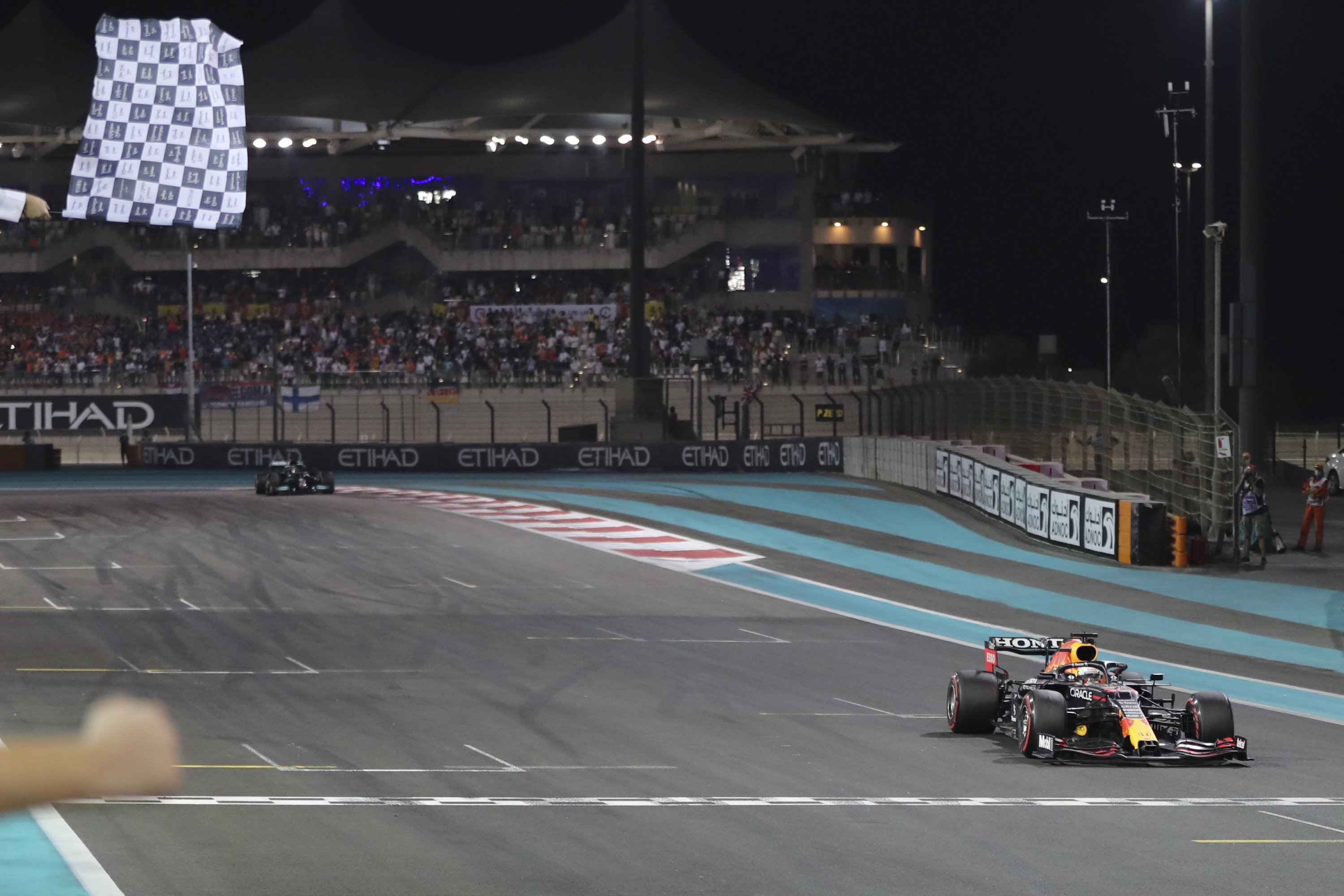 Red Bull's Dutch driver Max Verstappen (R) crosses the finish line to win the 2021 Abu Dhabi Grand Prix and the F1 world championship at Yas Marina Circuit, Abu Dhabi, UAE, Dec. 12, 2021. (EPA Photo)
