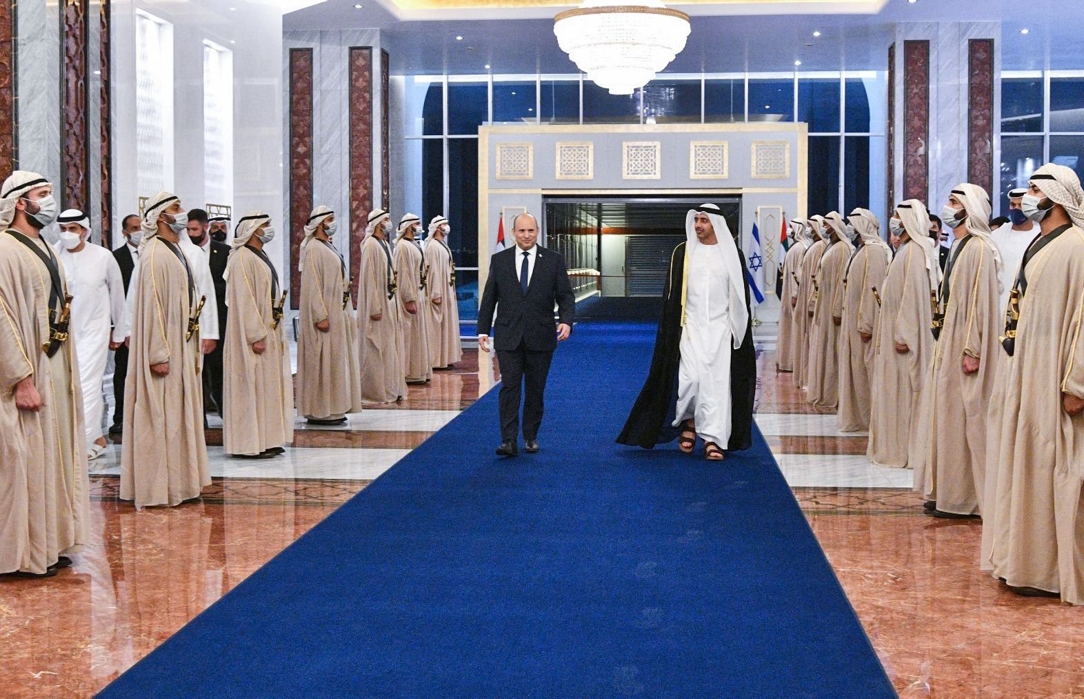 A handout picture released by the Israeli Government Press Office (GPO) shows Emirati Foreign Minister Sheikh Abdullah bin Zayed Al Nahyan (R) receiving Israeli Prime Minister Naftali Bennett following his arrival in Abu Dhabi, on Dec.12, 2021. (AFP Photo/GPO)