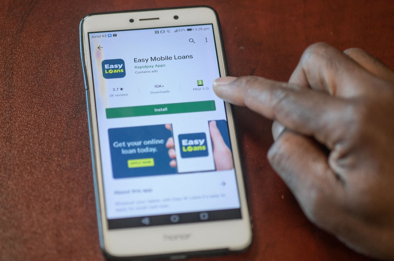 A man holds his smartphone with the display of different types of mobile loan lending service displayed on his screen, in this illustration photo taken in Nairobi, Dec. 8, 2021. (Photo by Simon MAINA / AFP)