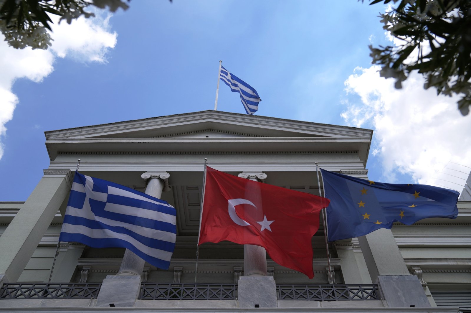 Greek (L) Turkish (C) and European Union flags wave on the foreign ministry house before a meeting betwen Greek Foreign Minister Nikos Dendias and his Turkish counterpart Mevlüt Çavuşoğlu in Athens, Greece, May 31, 2021. (AP File Photo)