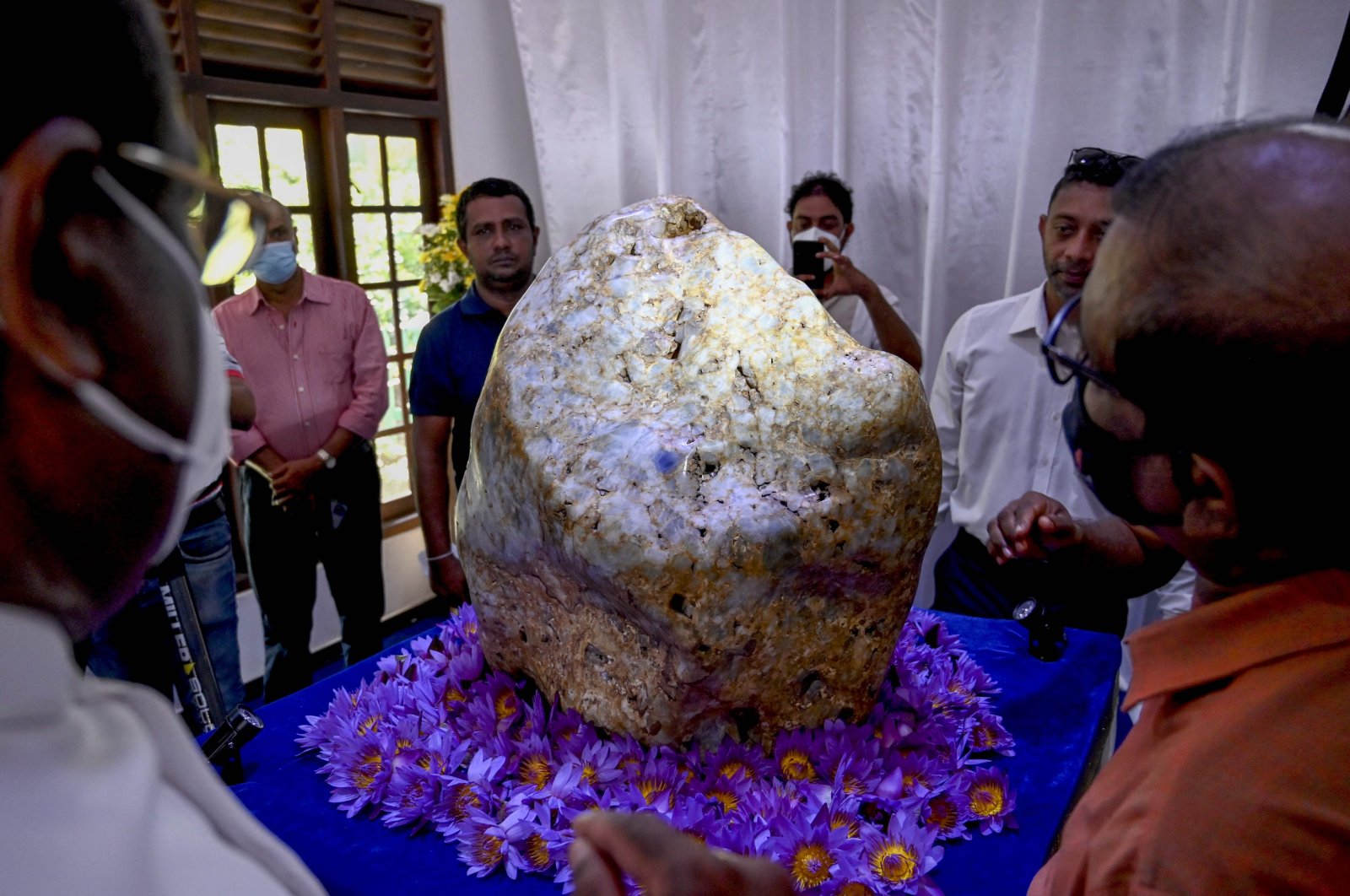 People inspect the single natural corundum (blue sapphire) named "Queen of Asia," considered the largest found in the world, in Horana, some 45 kilometers from Colombo, Sri Lanka, Dec. 12, 2021. (AFP Photo)