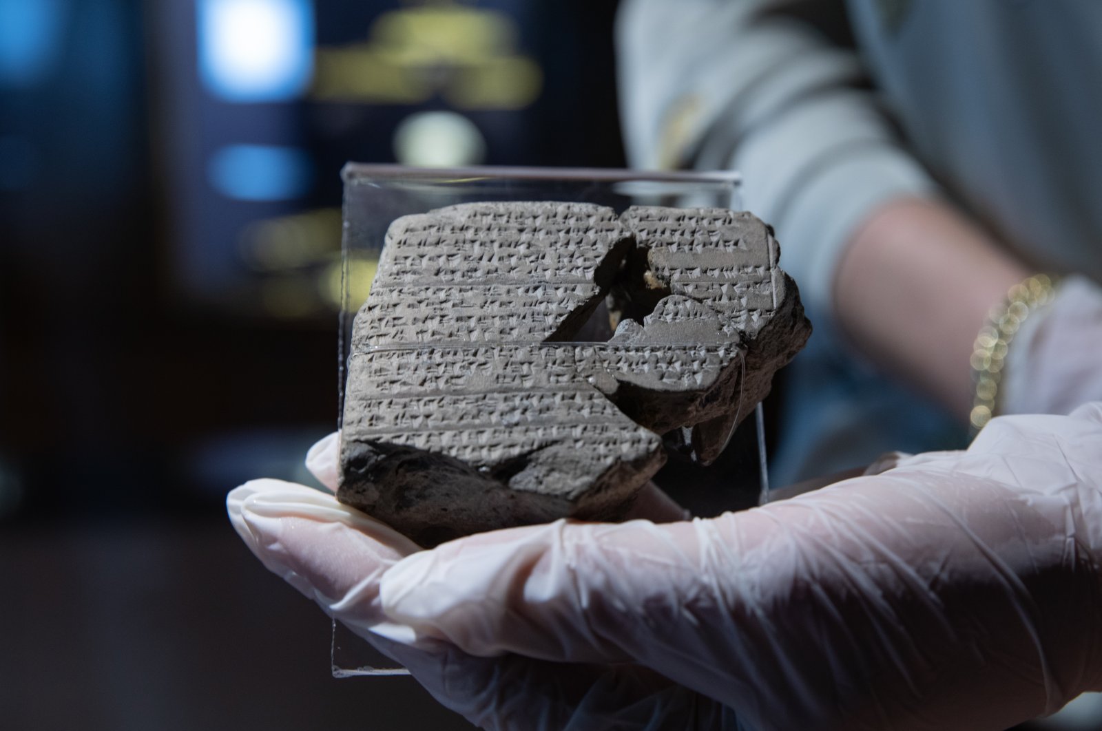 A staff member holds one of the four 3,500-year-old tablets describing several rituals are on display as part of the Izmir Archeology Museum&#039;s "You Will See What You Can&#039;t See" project, Izmir, Turkey, Dec. 11, 2021. (AA Photo)